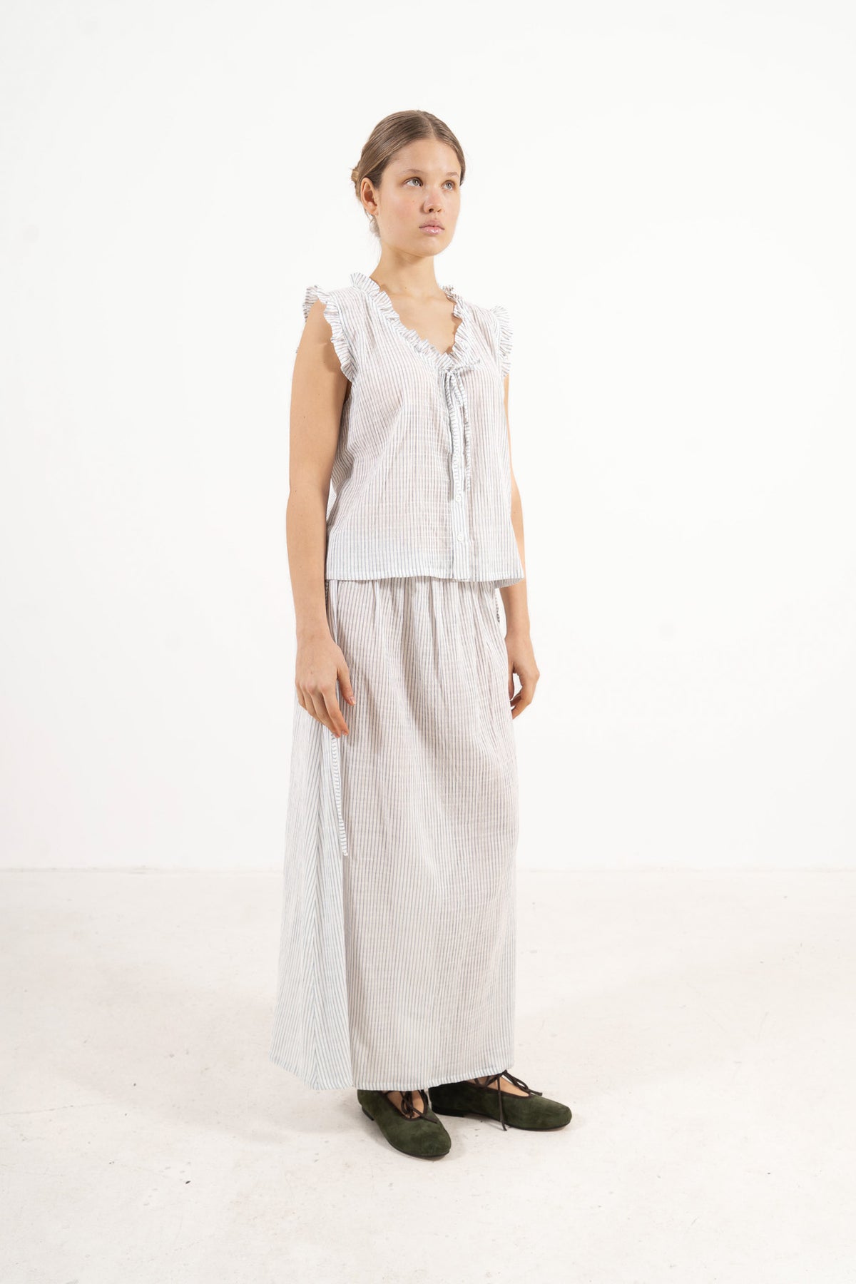 Profile studio portrait showcasing the relaxed fit, generous length, and pure structural lines of the MOCHA Rosy top and skirt.