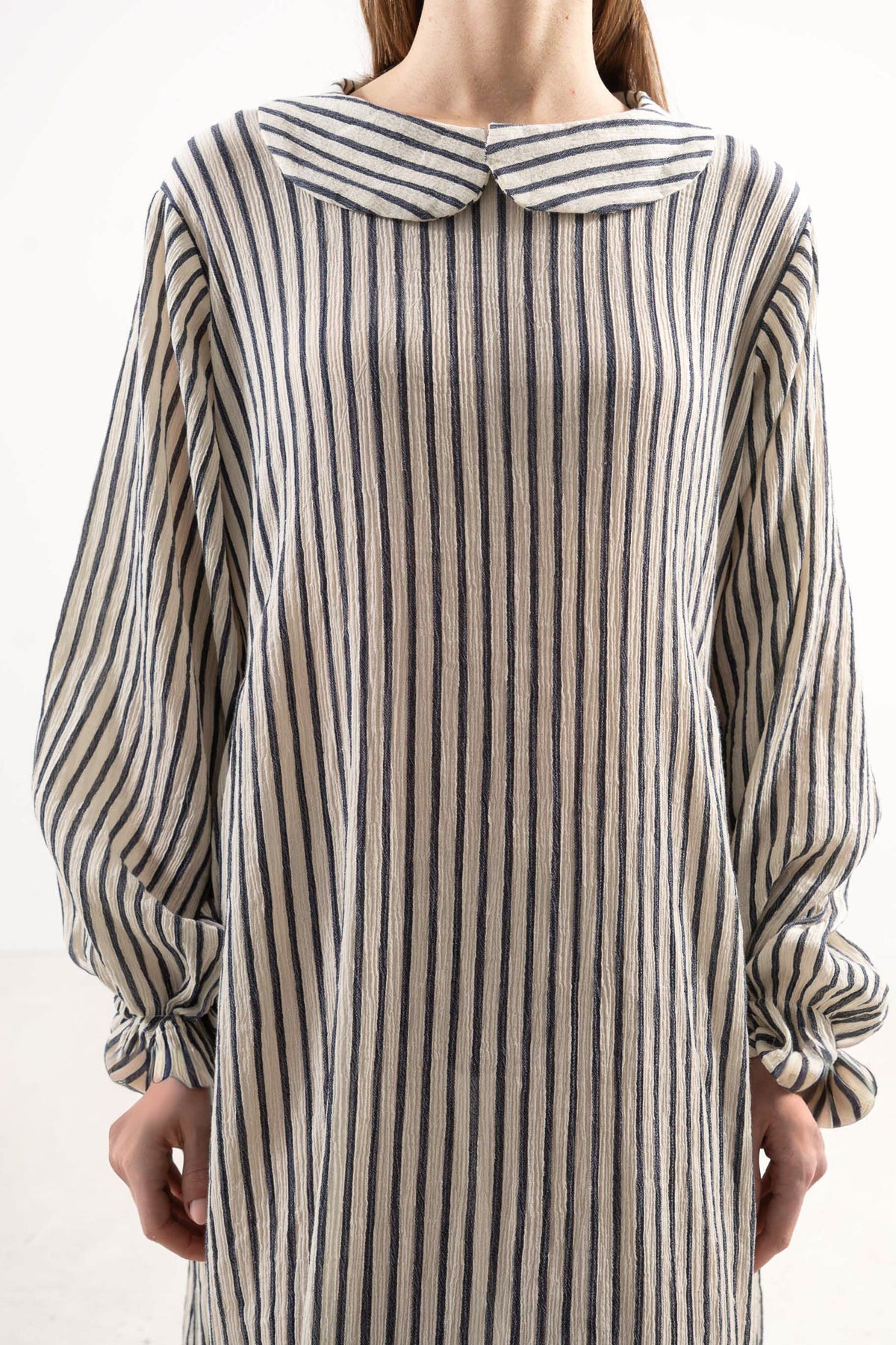 Close-up detail shot focusing on the delicate collar, fine ruffled details, and premium texture of the MOCHA striped cotton weave.