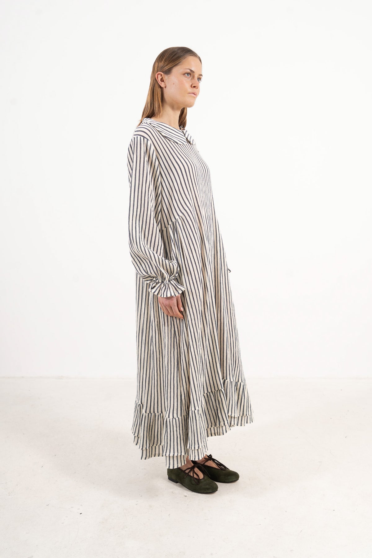 Profile studio portrait showcasing the refined long silhouette and graceful design of the MOCHA Sillage dress.