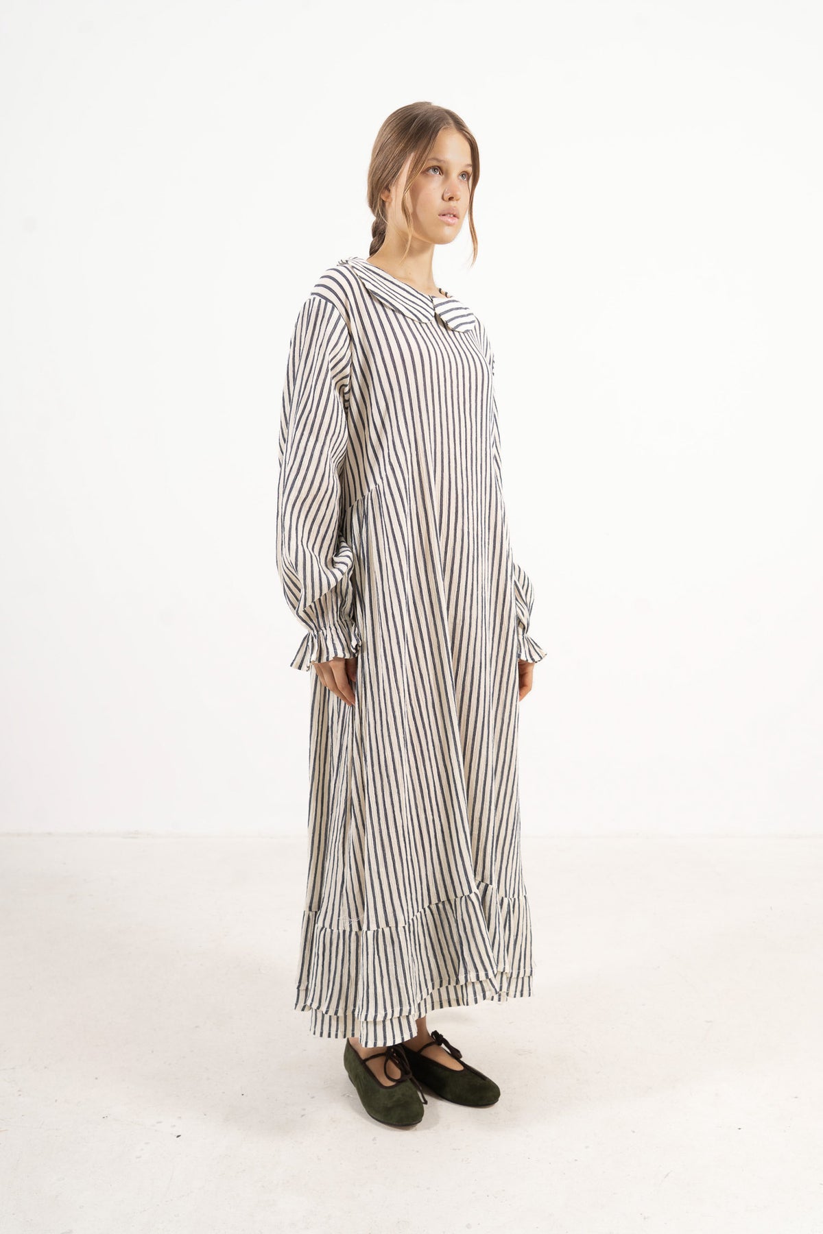 Profile studio portrait showcasing the refined long silhouette and graceful design of the MOCHA Sillage dress.
