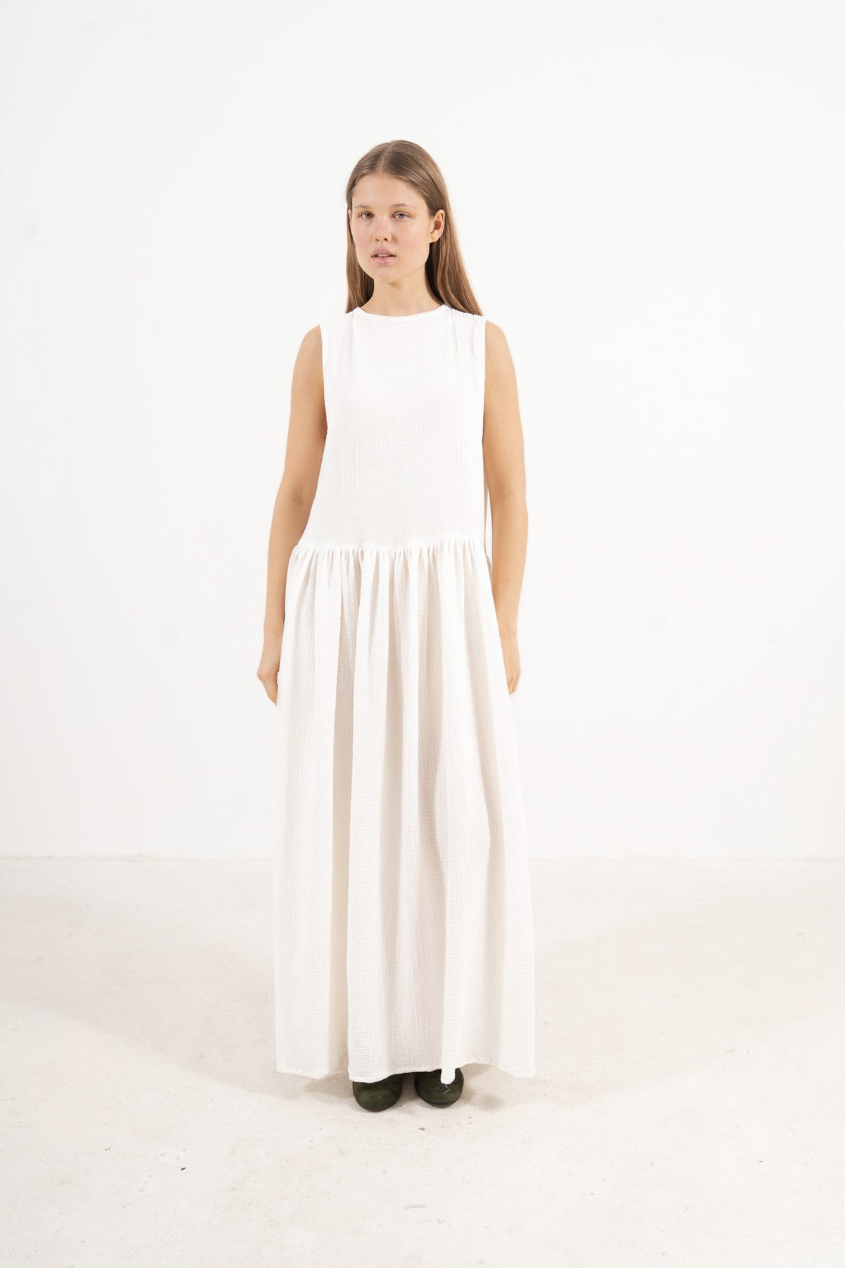 Side profile view of a model highlighting the elegant drape and clean, sophisticated silhouette of the MOCHA Nuage dress.