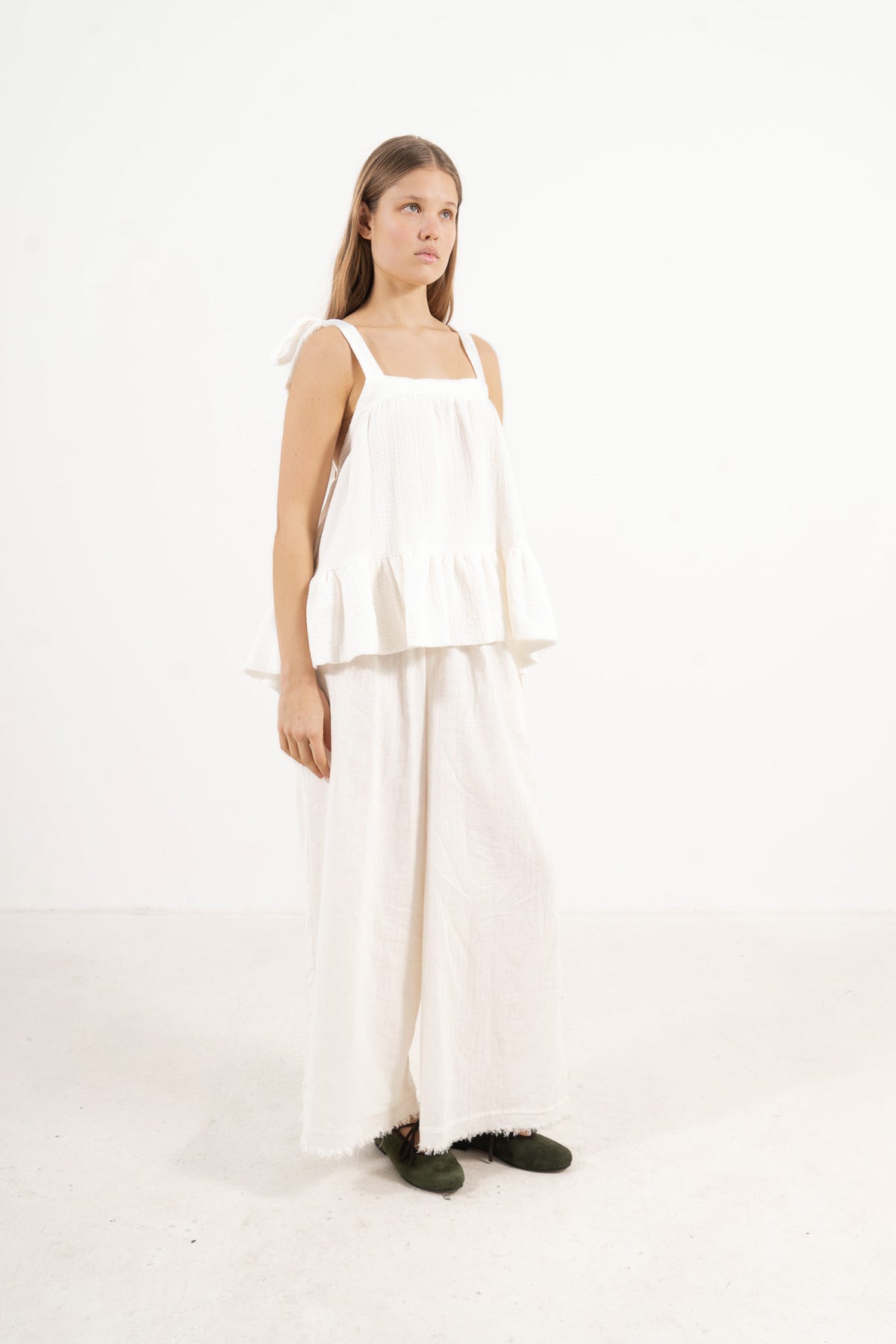 Profile studio portrait showcasing the versatile fit, clean lines, and pure structure of the MOCHA Belle top.