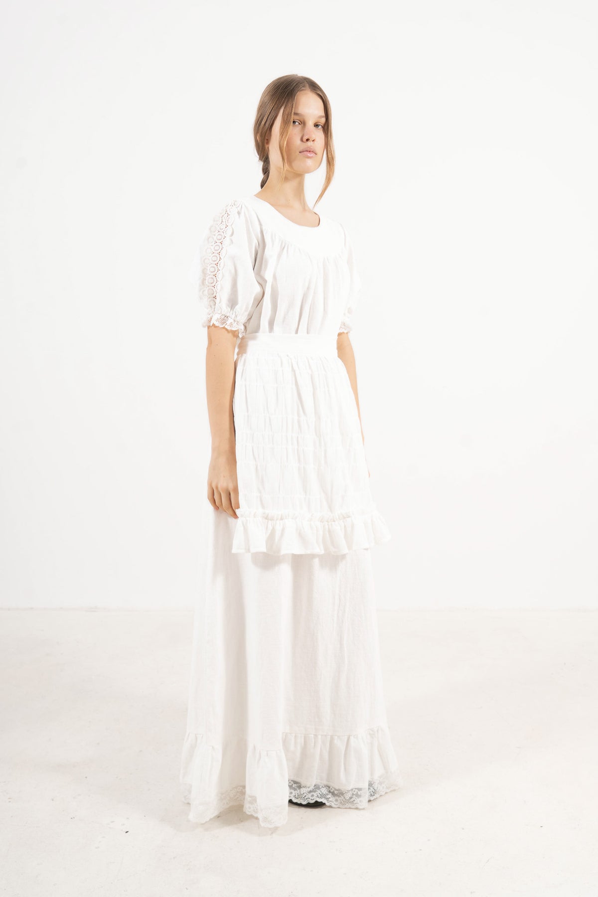 Side lookbook capture of the white organic cotton dress, emphasizing the beautiful drape, voluminous puff sleeves, and airy lightness.